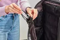 Person putting sunglasses in Nomatic Travel Pack Laptop Bag 20L