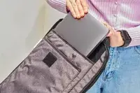 Person putting laptop in sleeve of Nomatic Travel Pack Laptop Bag 20L