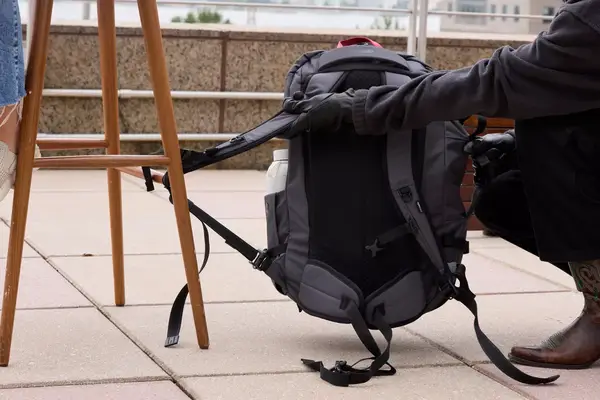 A person lifts up the strap on the Pacsafe Venturesafe EXP45 Anti-Theft Carry-On Travel Pack