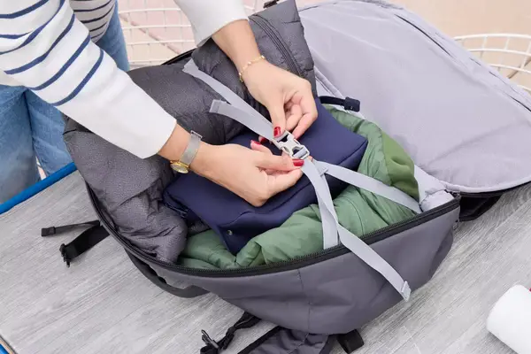 A person secures travel items in the Pacsafe Venturesafe EXP45 Anti-Theft Carry-On Travel Pack