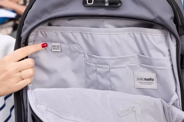 A person points to a RFID Safe tag on the Pacsafe Venturesafe EXP45 Anti-Theft Carry-On Travel Pack