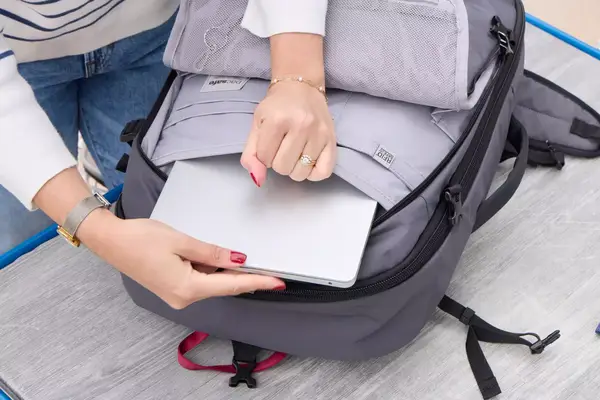 A person places a tablet into the Pacsafe Venturesafe EXP45 Anti-Theft Carry-On Travel Pack