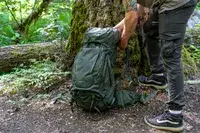 A person in outdoors attire handling a Osprey Kestrel 58L Men
