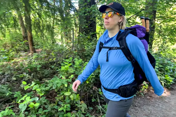 A person hiking on a forest trail with a ULA Equipment Circuit