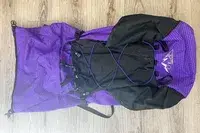 A mountaineering ULA Equipment Circuit on a wooden floor, featuring purple and black fabric with grid and diamond patterns