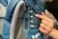 Person adjusting a REI Co-op Traverse 60 Pack strap with torso length markers