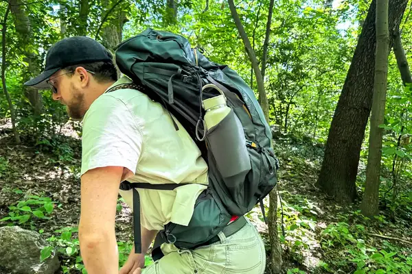A person hiking in a forest with a Gregory Katamai 55 - Hiking Backpack 