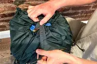 Hands securing the drawstring of a Gregory Katamai 55 - Hiking Backpack 