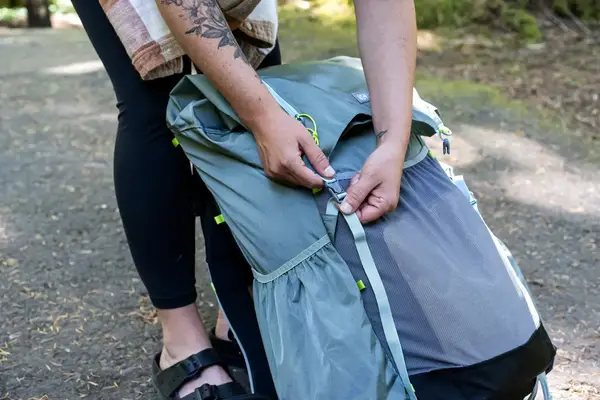Person adjusting strap on a Gossamer Gear Mariposa 60 Backpack
