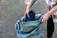 Person placing a small bag into a Gossamer Gear Mariposa 60 Backpack