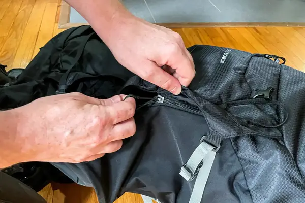 Hands adjusting the zipper of a Osprey Atmos AG 65 Men