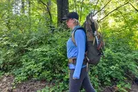 Person hiking with a The North Face Trail Lite 50 Backpack in a forested area