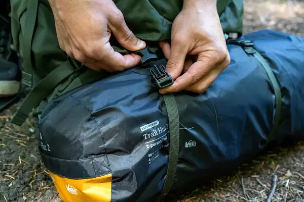 Person fastening the buckle on Osprey Kestrel 58L Men