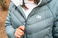 A hand holding the zipper of a worn Outdoor Research Women