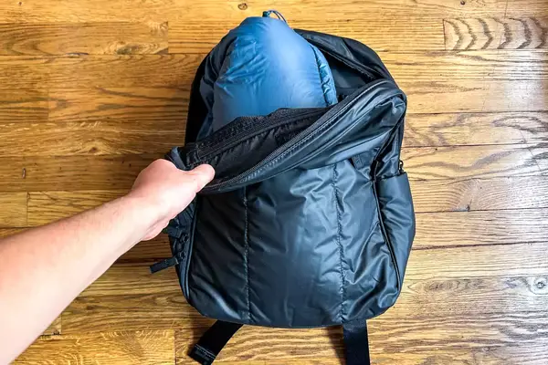 Person packing Hikerkind Packable Down Puffer 0.1 in a bag.