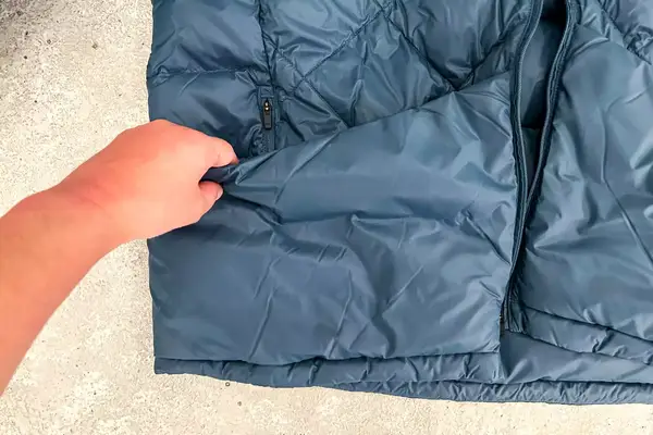 Person grabbing the pocket of Hikerkind Packable Down Puffer 0.1.