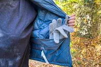 Gloves sticking out of inner pocket of Hikerkind Packable Down Puffer 0.1.