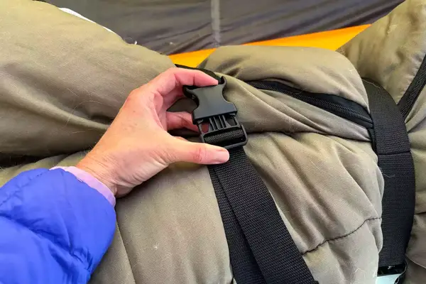 A person secures the straps on the Guide Gear -30 Sleeping Bag