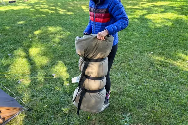 A person holds the rolled up Guide Gear -30 Sleeping Bag