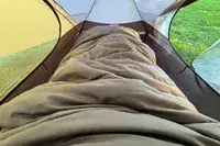 A person sleeps inside the Guide Gear -30 Sleeping Bag