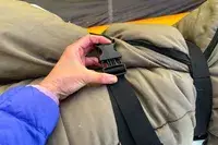 A person secures the straps on the Guide Gear -30 Sleeping Bag