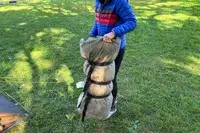 A person holds the rolled up Guide Gear -30 Sleeping Bag