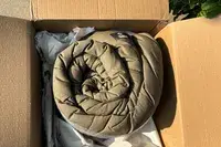 The Guide Gear -30 Sleeping Bag rolled up in a shipping box