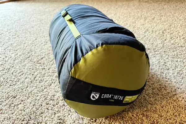 The Nemo Coda Genderless Endless Promise Down Mummy Sleeping Bag inside a storage bag