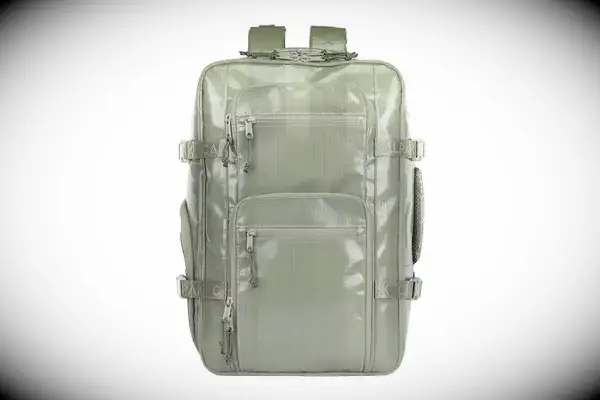 Dagne Dover Lagos Convertible Duffle Bag staged on a rug in front of a chair and side table