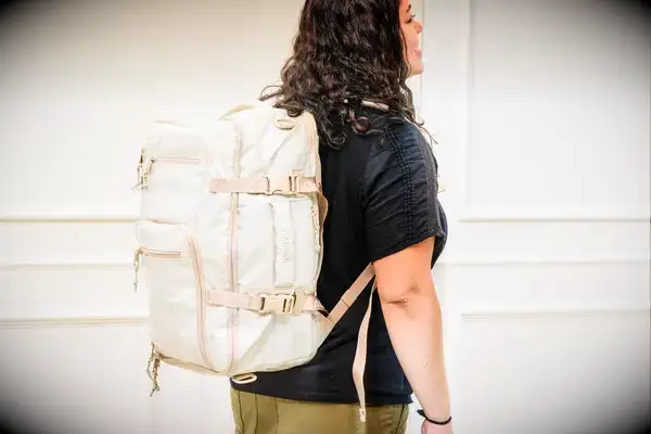 A person wears the Calpak Terra 26L Laptop Duffel Backpack