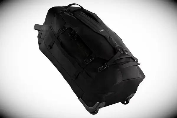 A person wears the Calpak Terra 26L Laptop Duffel Backpack