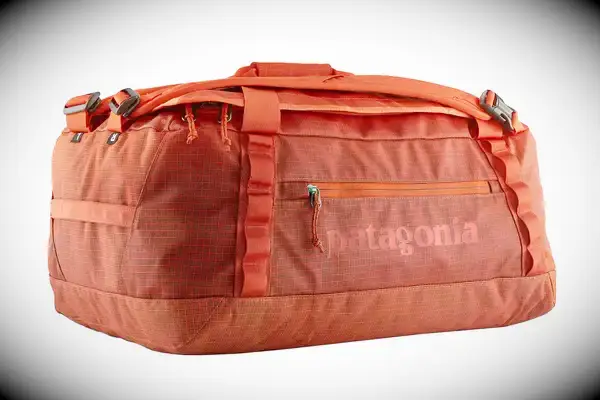 A person carrying the Dagne Dover Lagos Convertible Duffle Bag by its handle