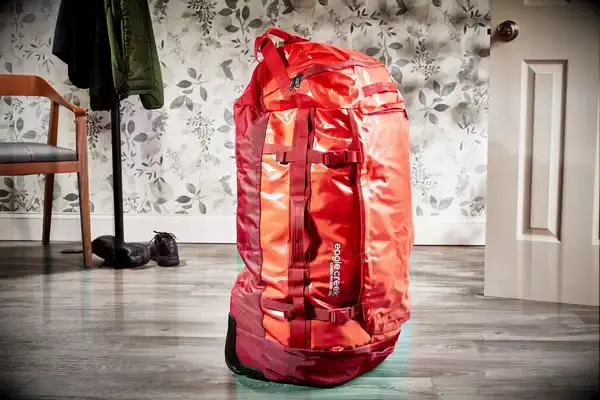 A person secures clothing inside the Calpak Terra 26L Laptop Duffel Backpack