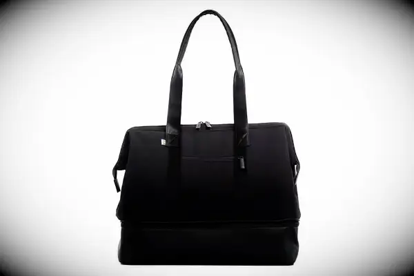 A person places the Away The Outdoor Convertible Backpack 45L into an overhead compartment