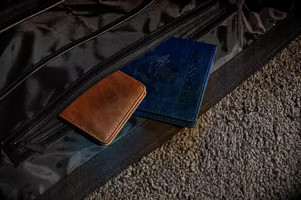 A wallet and a passport sticking out of the The Convertible Weekender