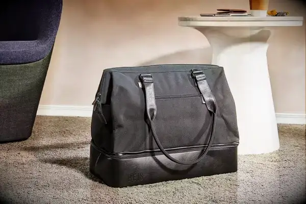 The Convertible Weekender on the floor next to furniture