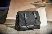 The Convertible Weekender on the floor next to furniture