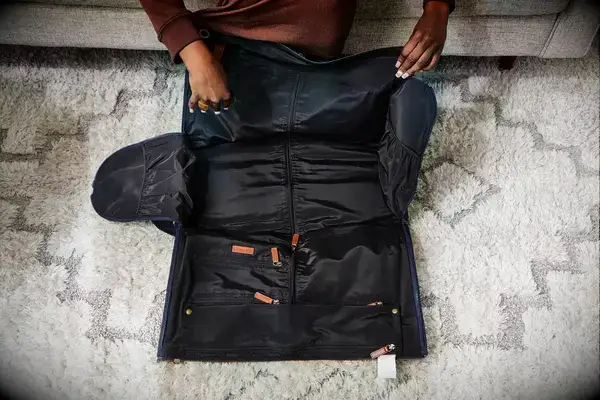 Hands opening the Mark & Graham Commuter 2-in-1 Garment Bag