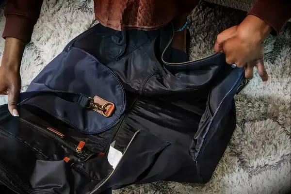 Hands opening the Mark & Graham Commuter 2-in-1 Garment Bag