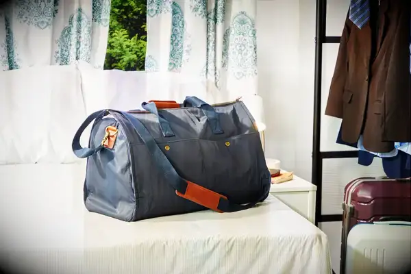 Mark & Graham Commuter 2-in-1 Garment Bag on a bed