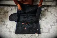 Hands opening the Mark & Graham Commuter 2-in-1 Garment Bag