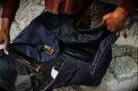 Hands opening the Mark & Graham Commuter 2-in-1 Garment Bag