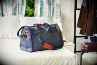Mark & Graham Commuter 2-in-1 Garment Bag on a bed