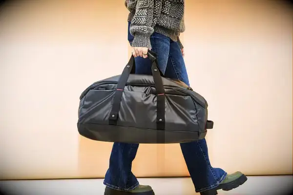 A person carries a Samsonite Ecodiver Small Duffel bag