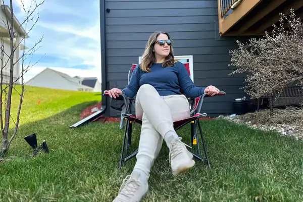 A person sits on the GCI Outdoor Kickback Rocker Chair