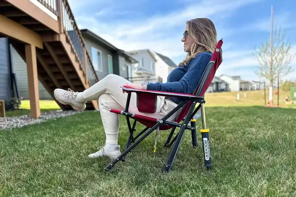 A person sits in the GCI Outdoor Kickback Rocker Chair