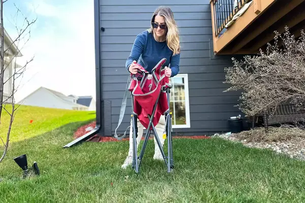 A person unfolds the GCI Outdoor Kickback Rocker Chair