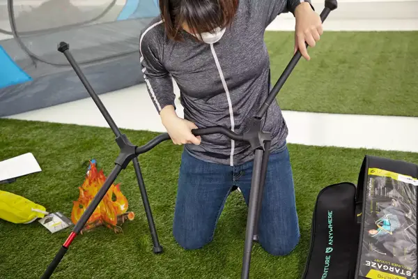 A person putting the NEMO Moonlite Reclining Camp Chair together