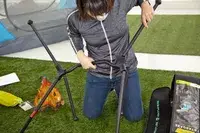 A person putting the NEMO Moonlite Reclining Camp Chair together