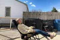 A person lounges in the GCI Outdoor Freeform Zero Gravity Lounger